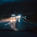 carros atravessando ponte à noite chovendo