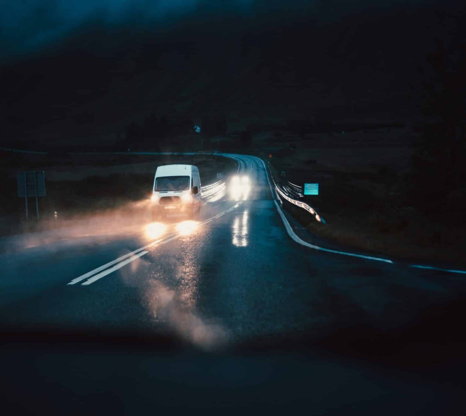 carros atravessando ponte à noite chovendo
